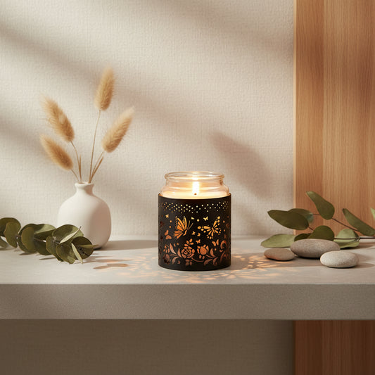 Candle in a decorative holder with butterfly and floral patterns