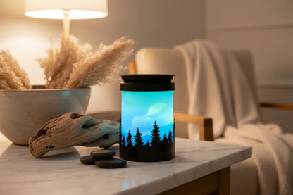 Wax melt burner with a design of a night sky with trees and the northern lights