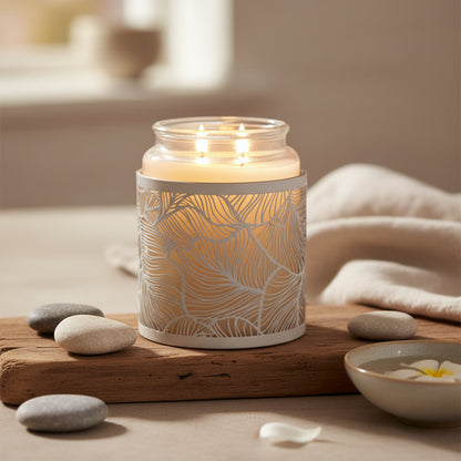 Candle in a decorative glass holder with leaf pattern 