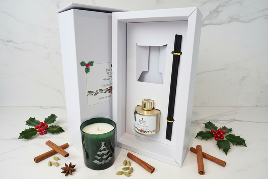 Christmas Bliss Winter Collection Gift Set with green etched glass candle and gold reed diffuser in white gift box styled on white marble with festive botanicals