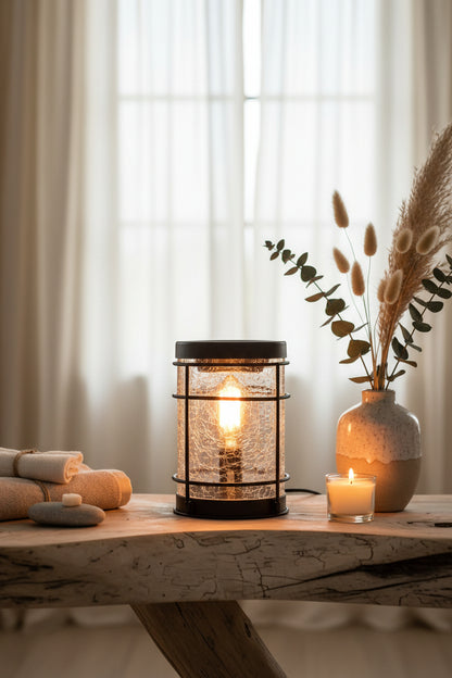 Decorative wax melt burner with crackle glass and black metal frame placed on a wooden table