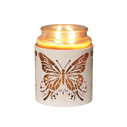 Candle in a holder with a butterfly design on a white background