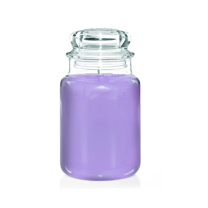 Glass jar candle filled with purple wax on a white background