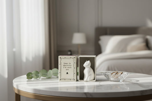 Small white cat figurine in a box with a quote