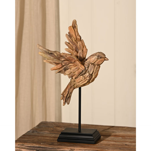 Wooden effect resin bird  on a stand against a beige curtain background