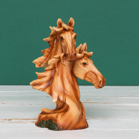 Wooden effect figurine of two horses on a white wooden surface with a green background