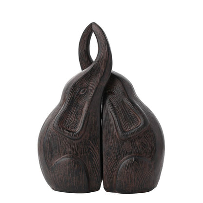 Dark Wood effect resin figurines of two elephants kissing on a white background