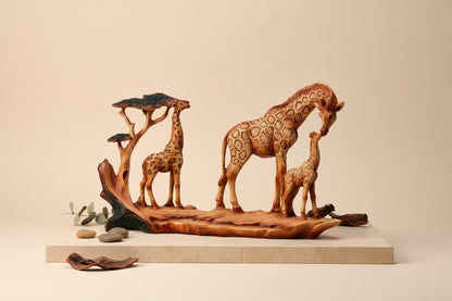 Wooden effect resin ornament of a family of giraffes on a stone surface