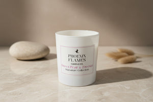 White candle with 'Phoenix Flames Candle Co.' label on a neutral background